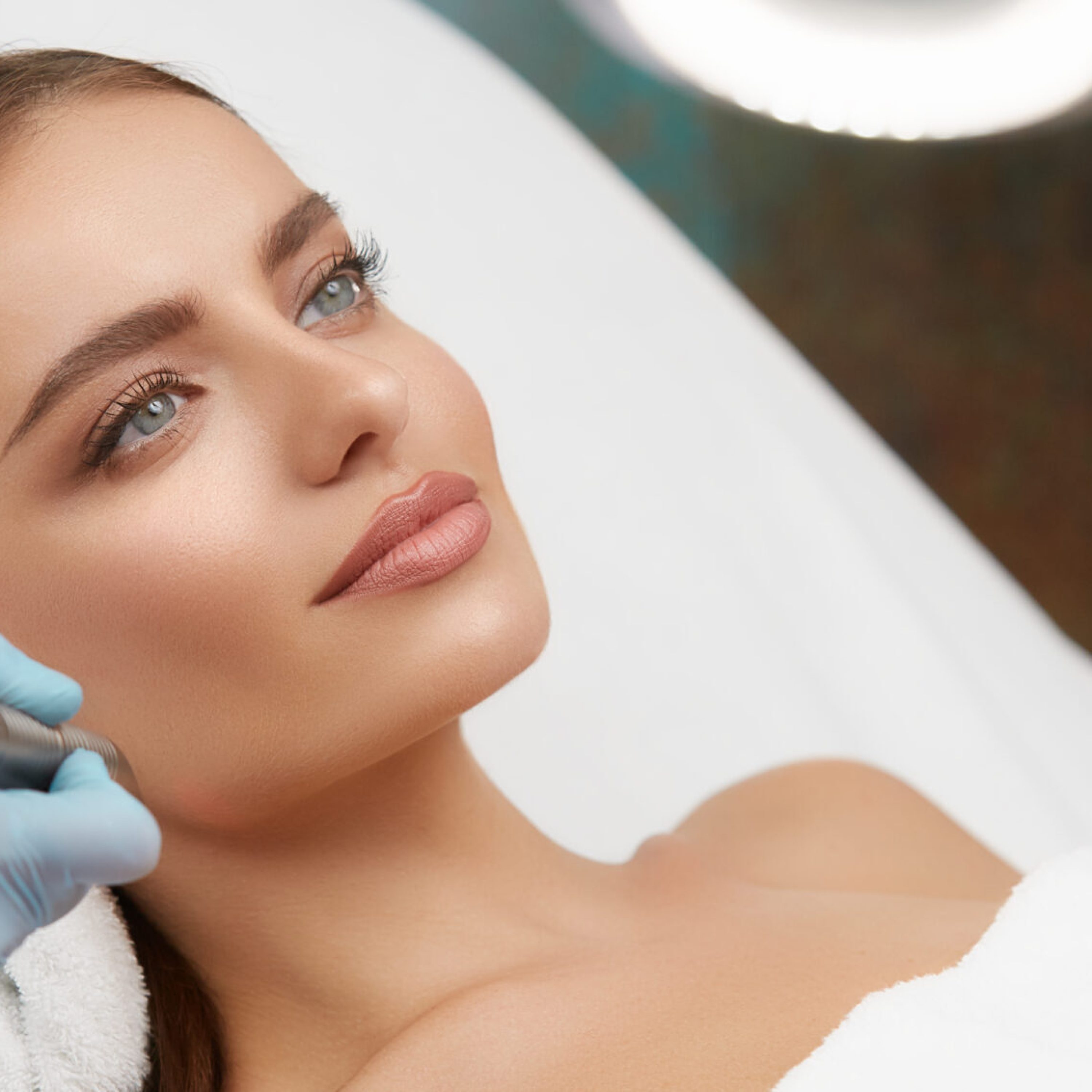 Cosmetology. Closeup Of Female Face having facial treatment in beauty salon. Cosmetic procedures in spa clinic.